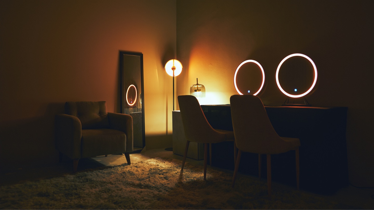 Green room — warm ambient lighting, makeup stations with ring lights, comfortable seating